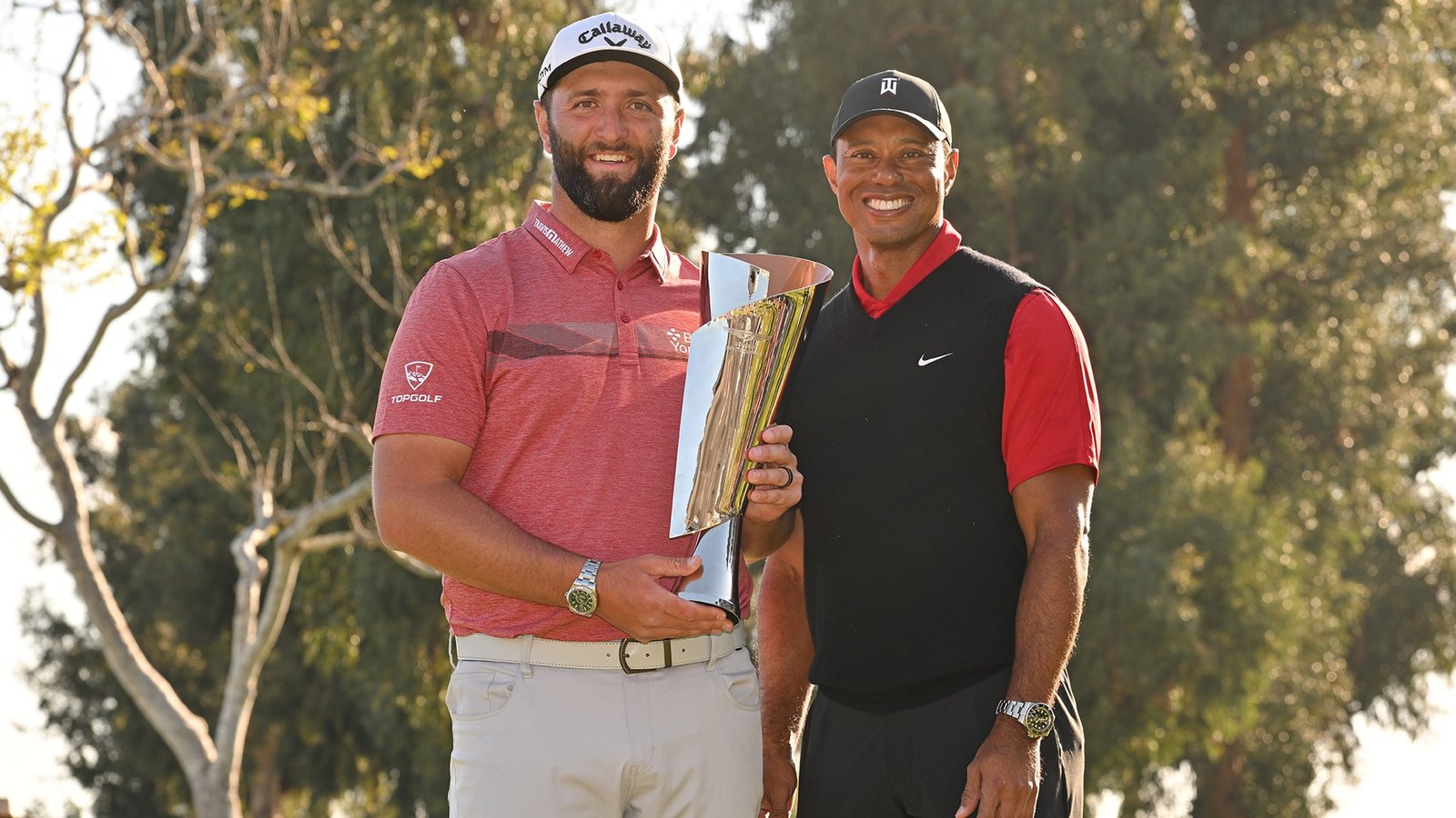 Jon Rahm with Genesis trophy and host Tiger Woods